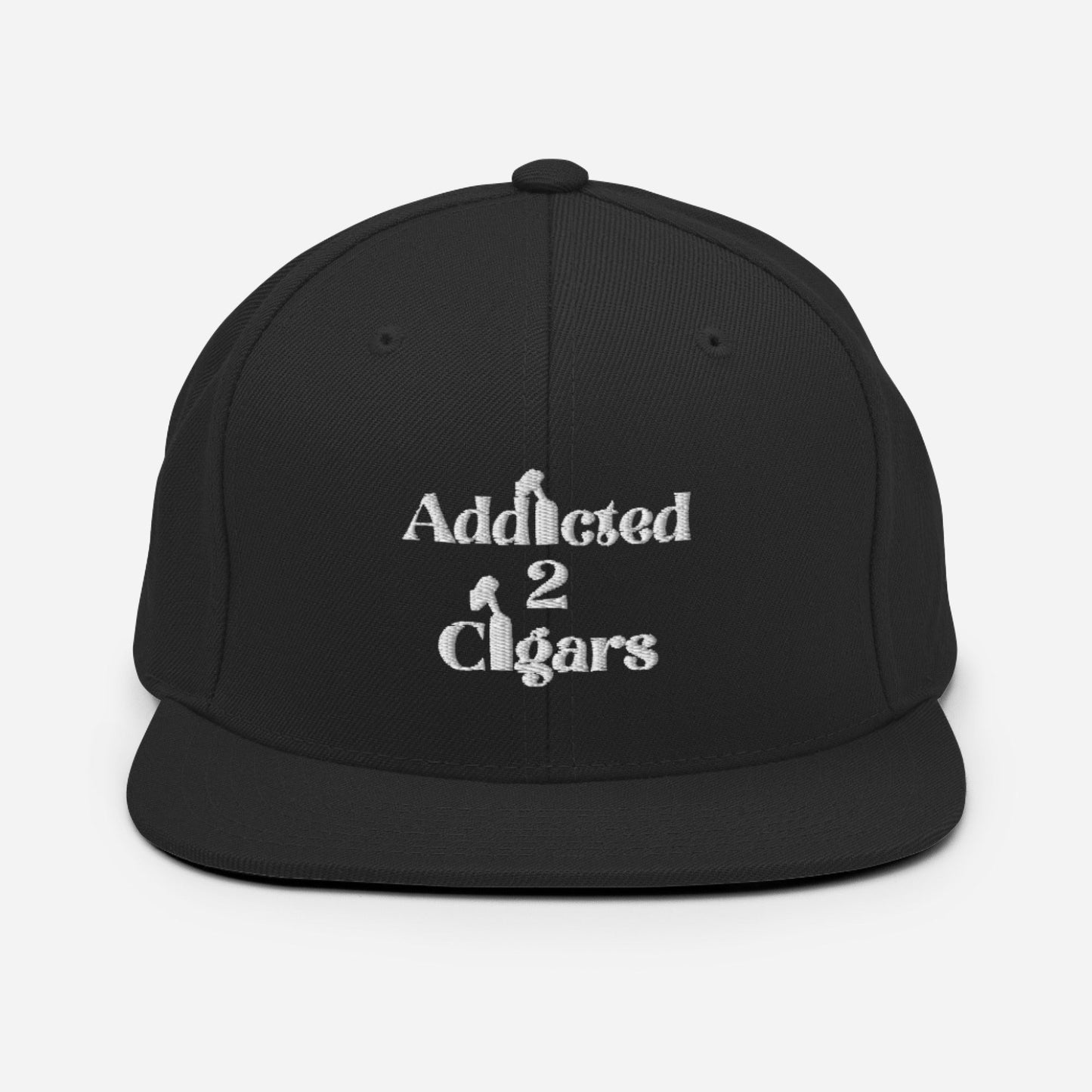 The Addicted2Cigars Embroidered Snapback Hat is showcased against a white background. Its front boasts playful embroidered text in white that reads "Addicted 2 Cigars," with small cigar graphics cleverly integrated into the letters. The black hat features a classic fit design and an adjustable snap closure for the perfect fit.