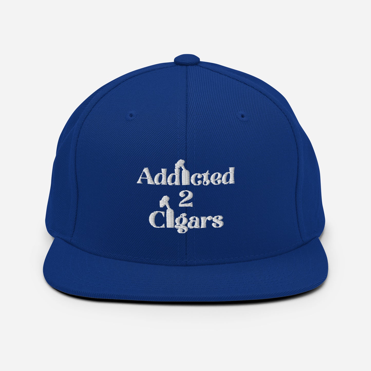 The Addicted2Cigars Embroidered Snapback Hat is a classic fit in green camo, featuring the phrase "Addicted 2 Cigars" embroidered in white across the front with stylized cigar images integrated into the letters. It comes with an adjustable snap closure for a perfect fit.