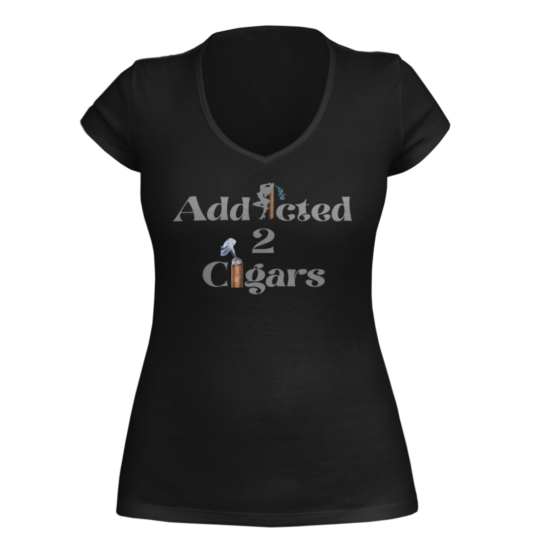 A gray short sleeve women's T-shirt featuring the phrase "Addicted 2 Cigars" printed on the front in a stylized font. The word "Addicted" has a cigar forming the letter "i," and the word "Cigars" includes a vertical cigar, symbolizing the passion for a good cigar.